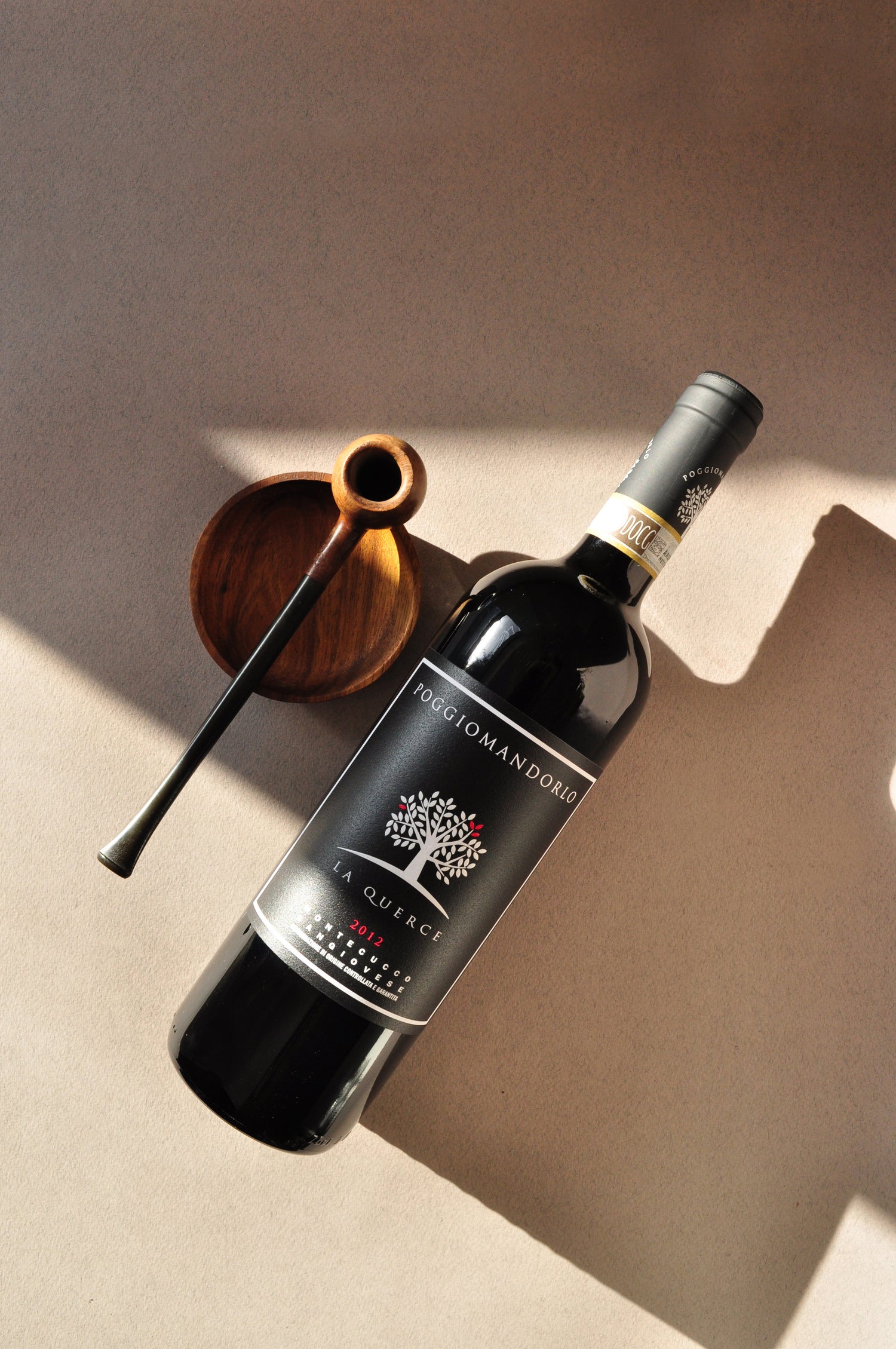 La Querce Sangiovese by Poggio Mandorlo in a moody lifestyle setting with a pipe — symbolizing the elegance and complexity of Tuscan minimal-intervention winemaking