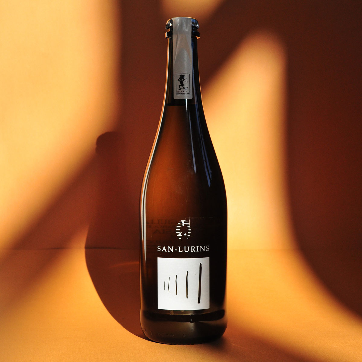 San Lurins Malvasia Pet-Nat in a lifestyle setting, representing natural Italian wine with saline notes and bottle-fermented purity