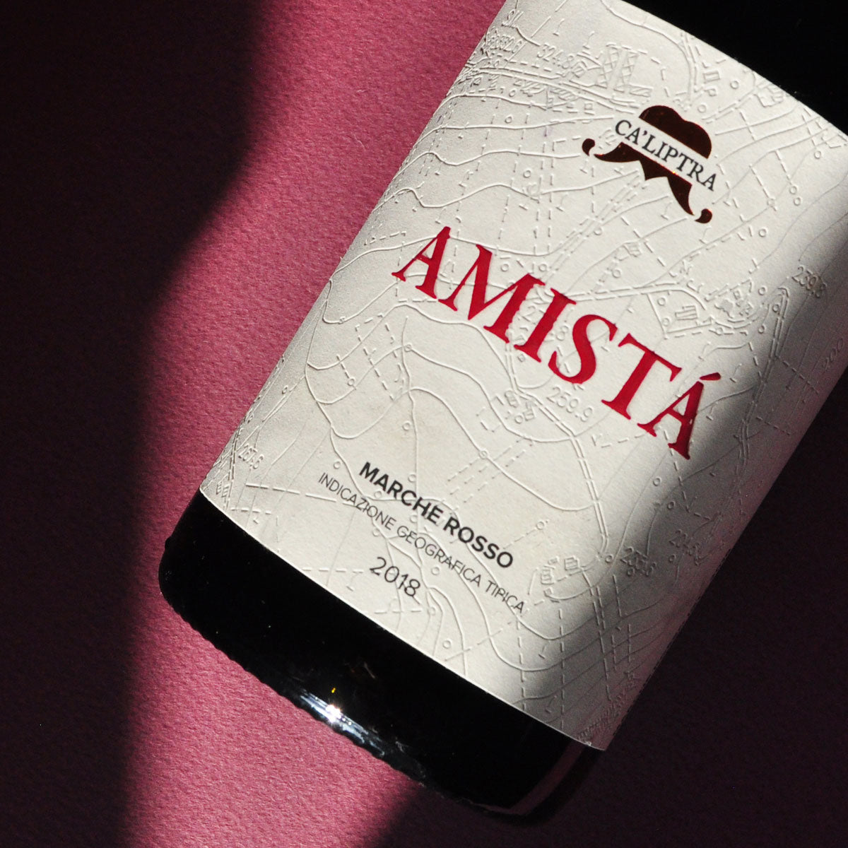 Close-up of Ca’Liptra Amista red wine label, an organic and natural Italian blend of Montepulciano and Sangiovese from Marche, showcasing minimalist design and small-scale craftsmanship