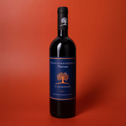 Styled image of Poggio Mandorlo Il Guardiano — a bold and elegant organic red wine from Montecucco, Tuscany, ideal for hearty meals and thoughtful pairings