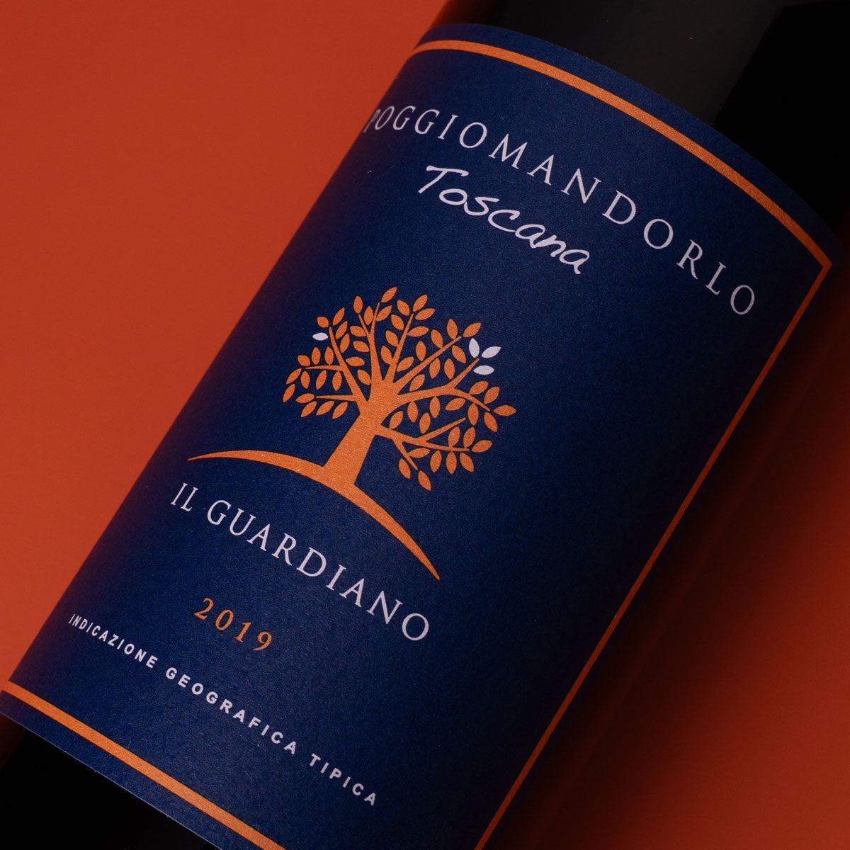 Close-up of Poggio Mandorlo Il Guardiano label — a sustainably made Sangiovese red wine from Tuscany’s Montecucco region, reflecting artisanal detail and terroir